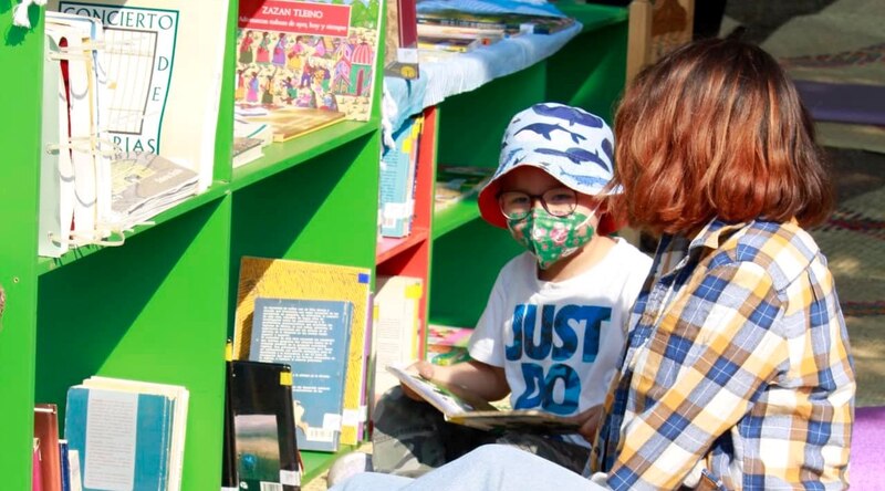 Una niña y un niño leyendo un libro en una biblioteca
