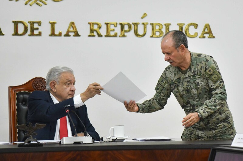 El presidente Andrés Manuel López Obrador entrega un documento al general Luis Cresencio Sandoval, secretario de la Defensa Nacional.