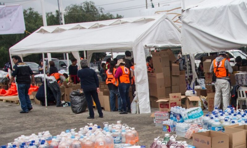 Un grupo de voluntarios prepara cajas de ayuda para los damnificados de un desastre natural.