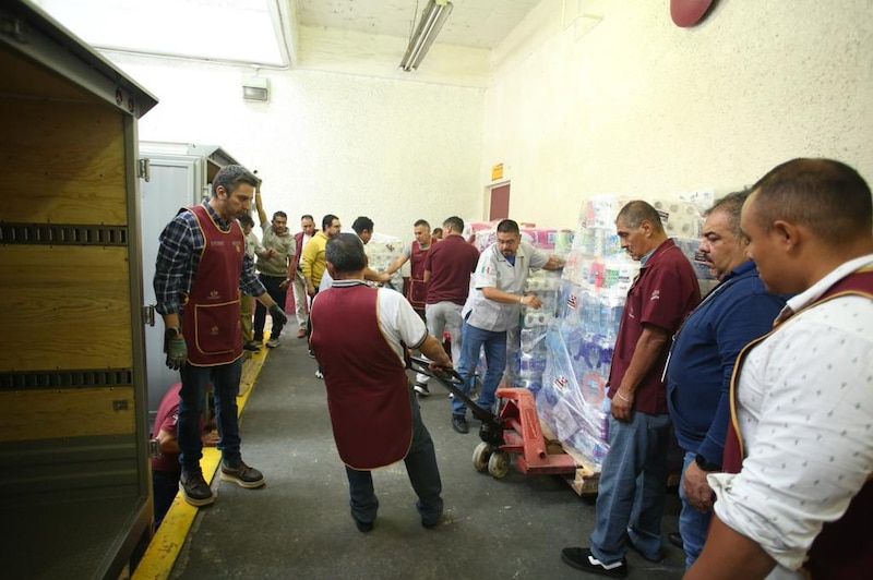 Voluntarios cargando donaciones en un almacén