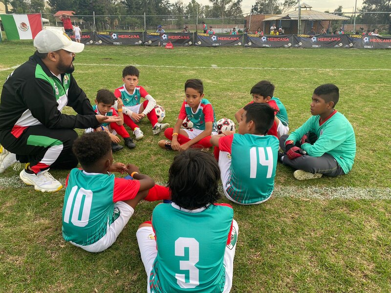 ¡Los niños escuchan atentos las indicaciones del entrenador!