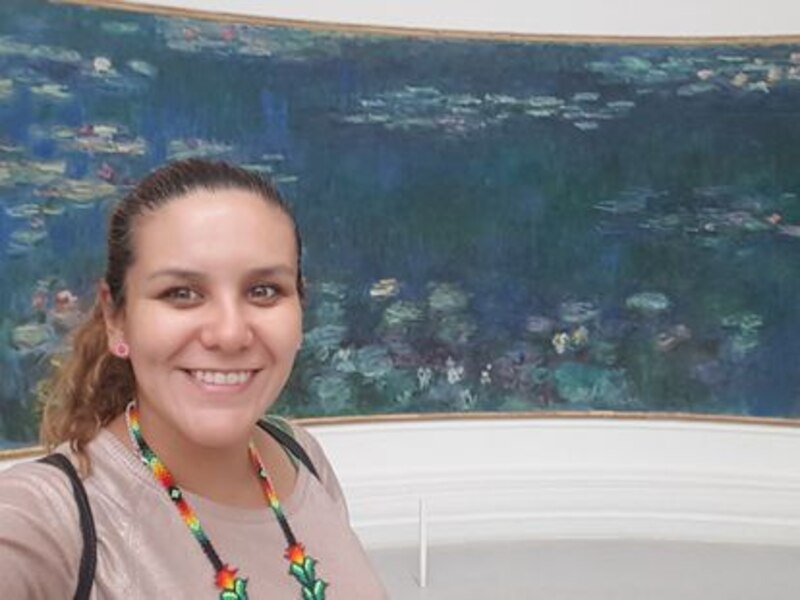 Mujer sonríe frente a un cuadro de Monet en el Museo de Orsay