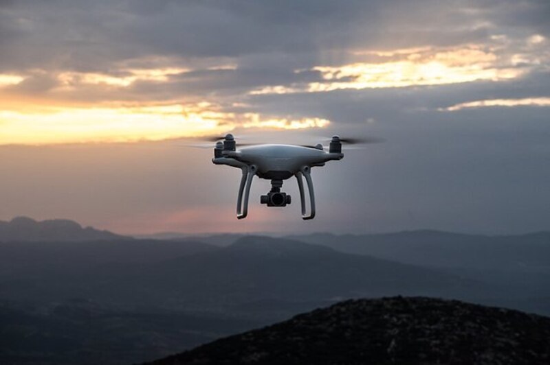 Dron volando sobre las montañas al atardecer