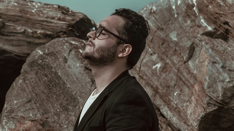Un hombre con gafas y barba con los ojos cerrados