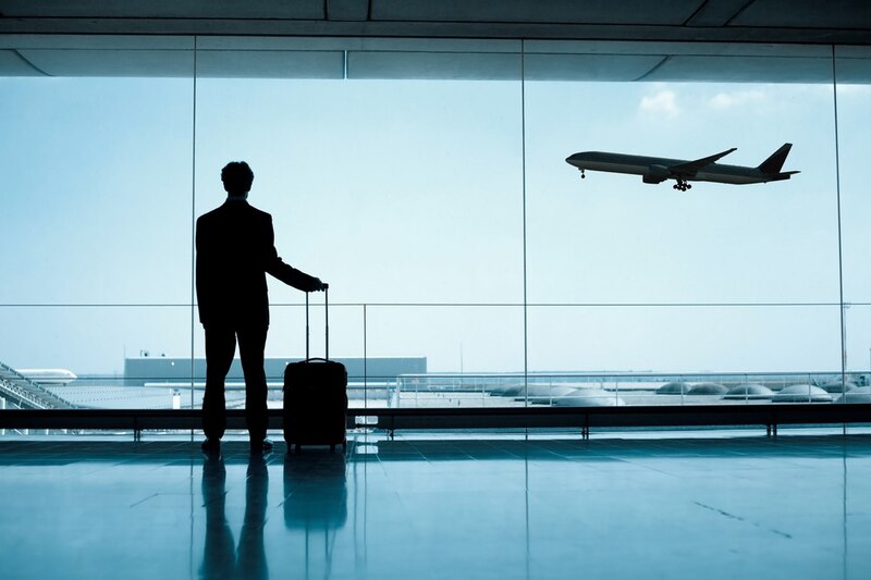 Un hombre de negocios mirando un avión despegar