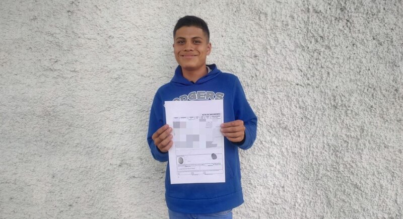 Un joven sostiene un papel con una imagen de un ojo