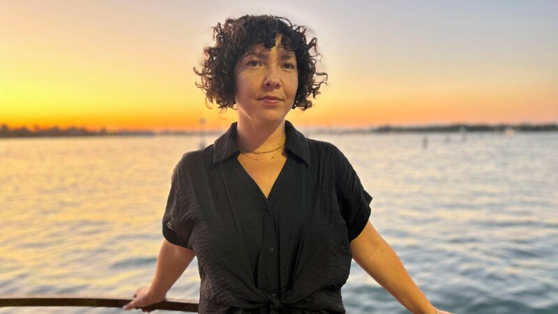 Mujer joven en un barco al atardecer