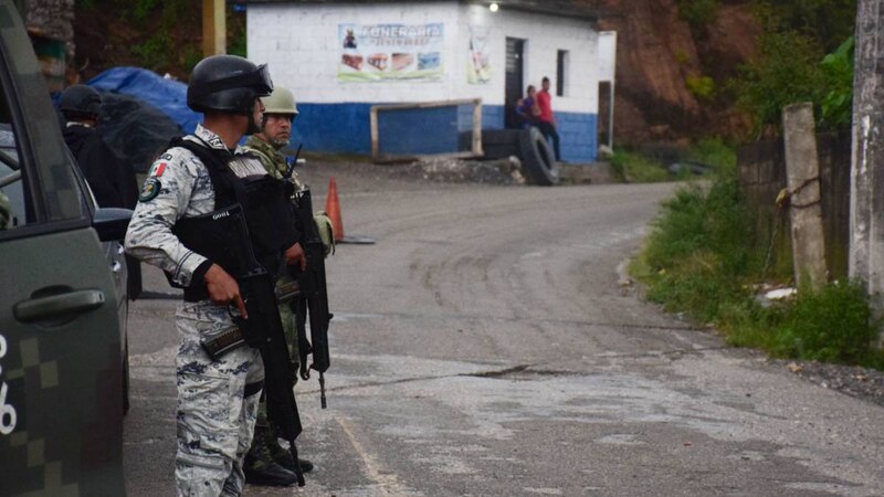 Militares mexicanos patrullan una calle en una zona rural