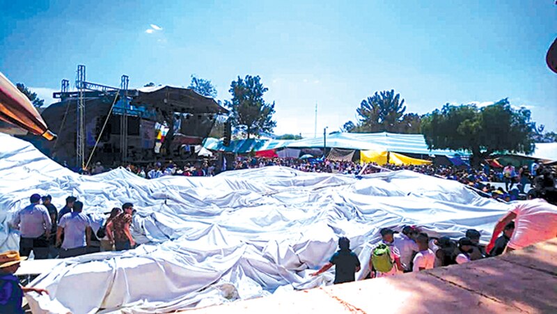 Multitud de personas en una plaza con una gran carpa blanca en el centro