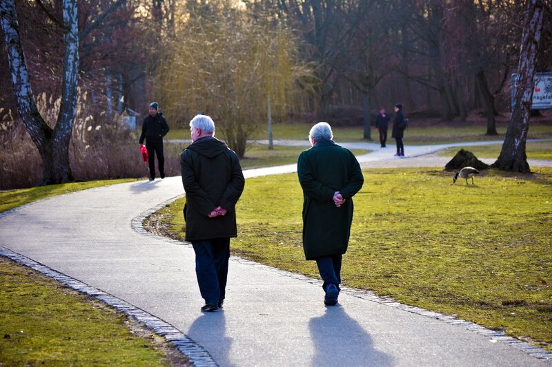 Dos hombres caminan por un parque