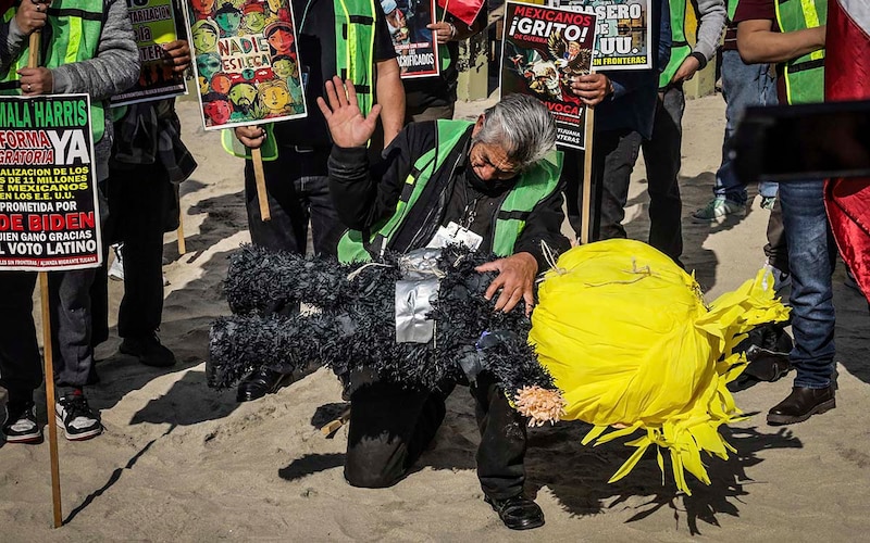 Migrante golpea piñata de Trump en protesta contra las deportaciones masivas en Tijuana.