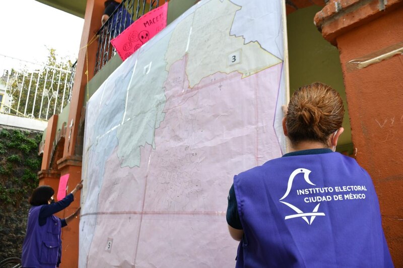 Mujeres colocando un cartel con un mapa