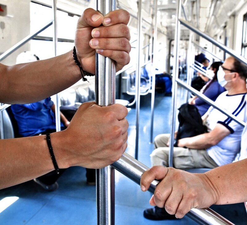 Pasajeros sujetándose de los pasamanos en un vagón de metro