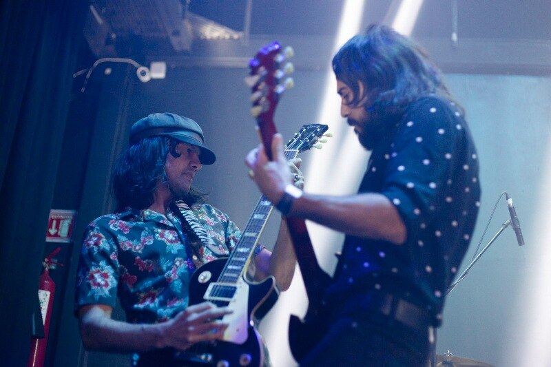 Dos hombres tocando la guitarra en un concierto