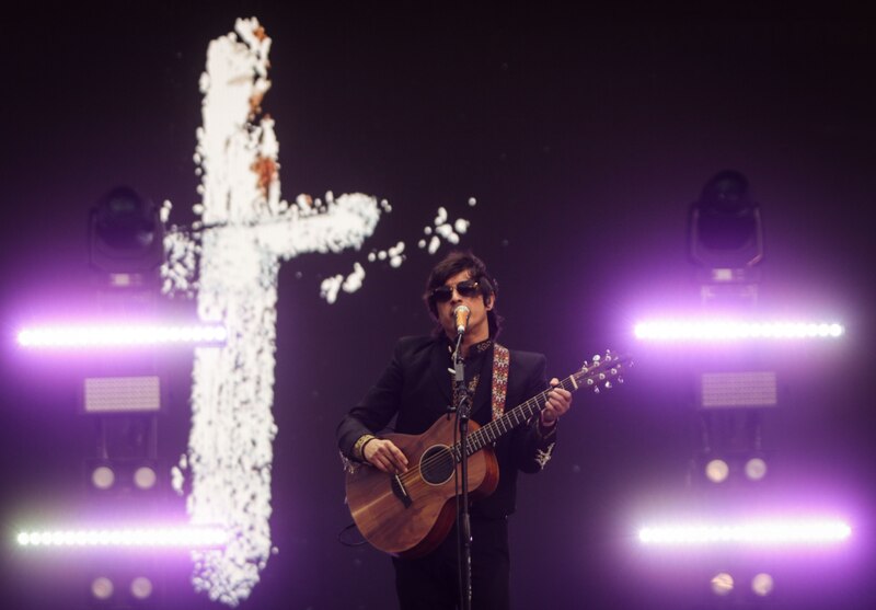 Cantante tocando la guitarra en un concierto
