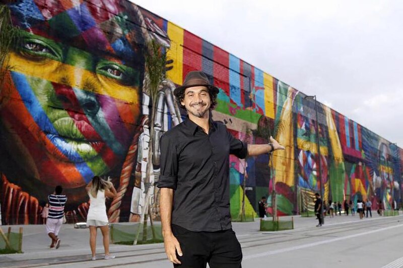 Artista urbano pinta un mural en una pared de la ciudad.