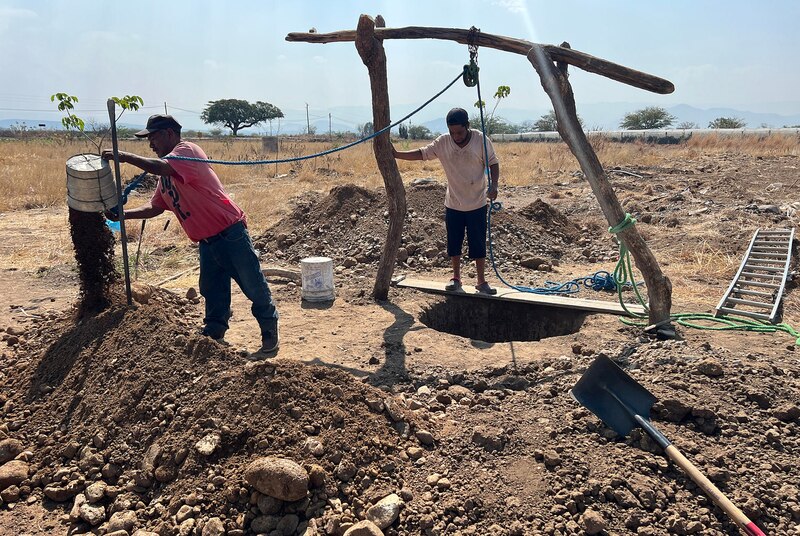 Dos hombres cavando un pozo