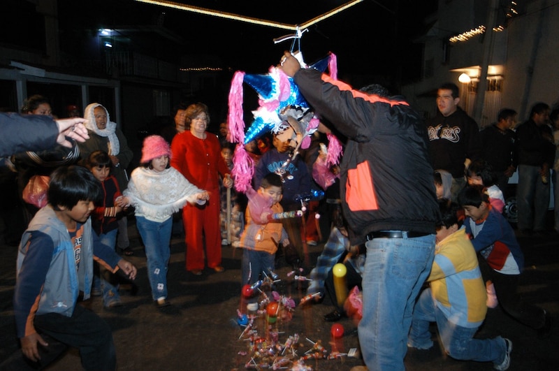 En diversas calles de la CDMX se realizan posada navideñas. Decenas de niños intentan romper la tradicional piñata.