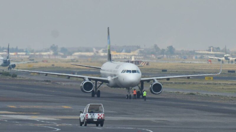 Un avión de pasajeros en la pista de un aeropuerto.