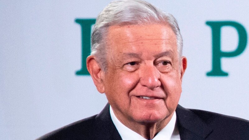 El presidente López Obrador sonríe durante una conferencia de prensa.