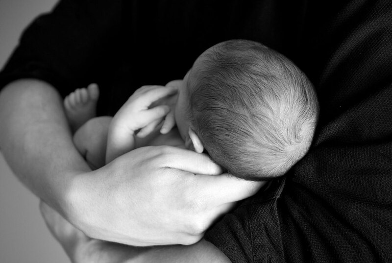 Un bebé recién nacido duerme en los brazos de su madre