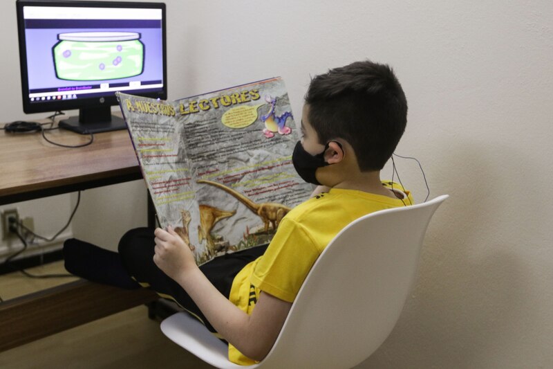 Niño leyendo un libro sobre dinosaurios