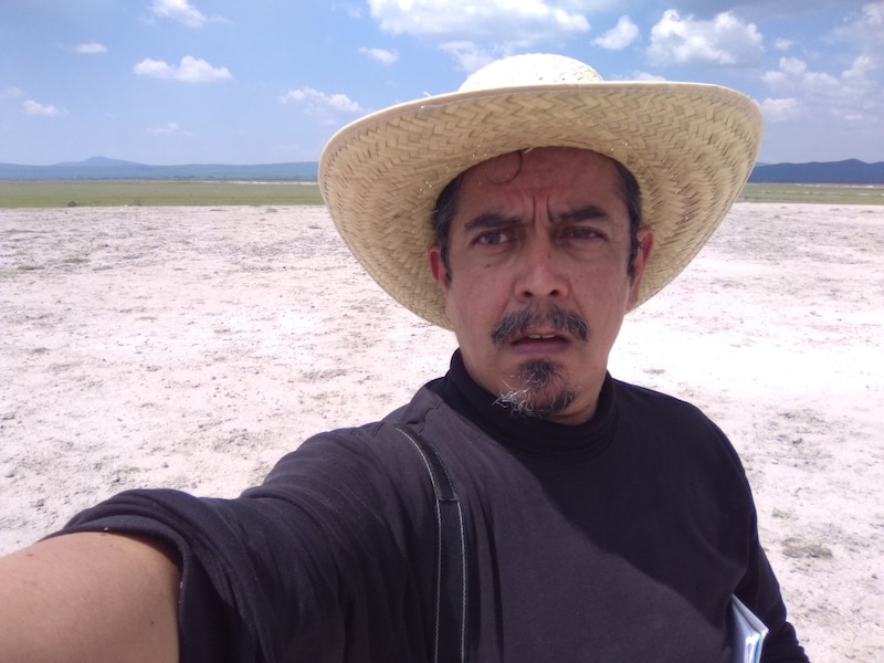 Un hombre con sombrero de paja en un campo