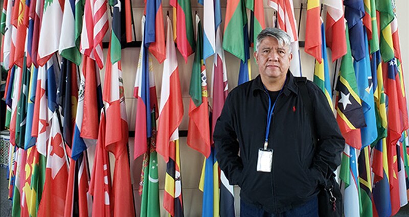 Un hombre con las banderas del mundo de fondo