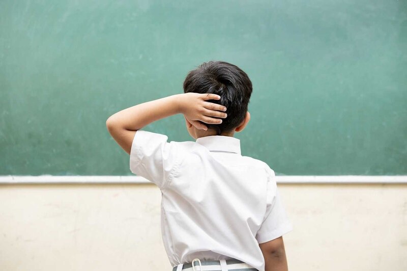 Niño pensando frente a una pizarra