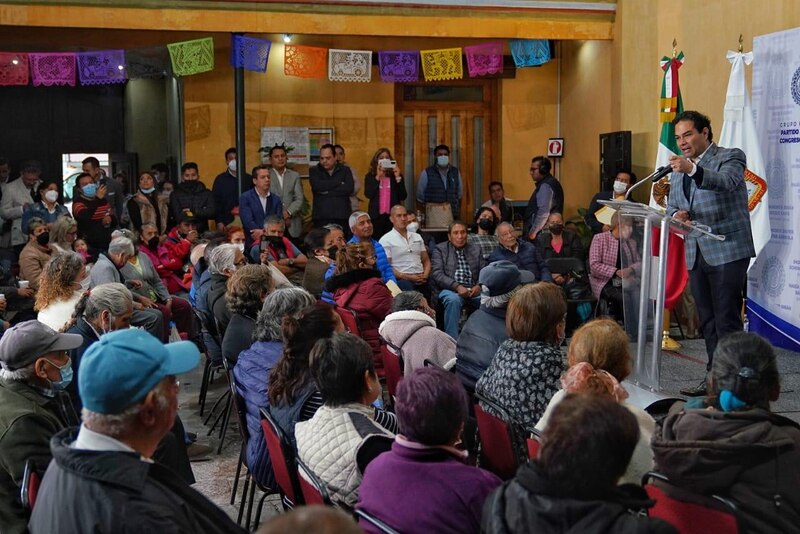 Político dando un discurso ante un grupo de personas mayores