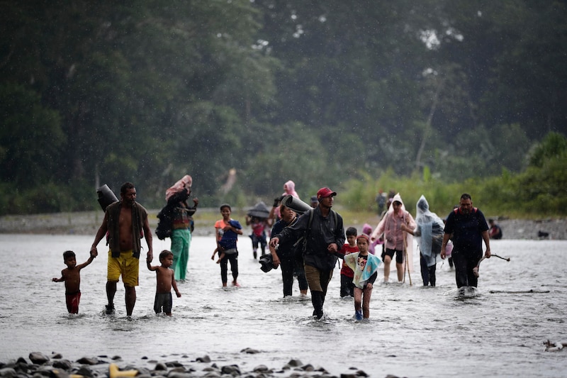 Migrantes cruzan un río en busca de una nueva vida