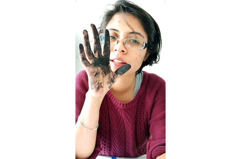 Mujer con la mano pintada de negro