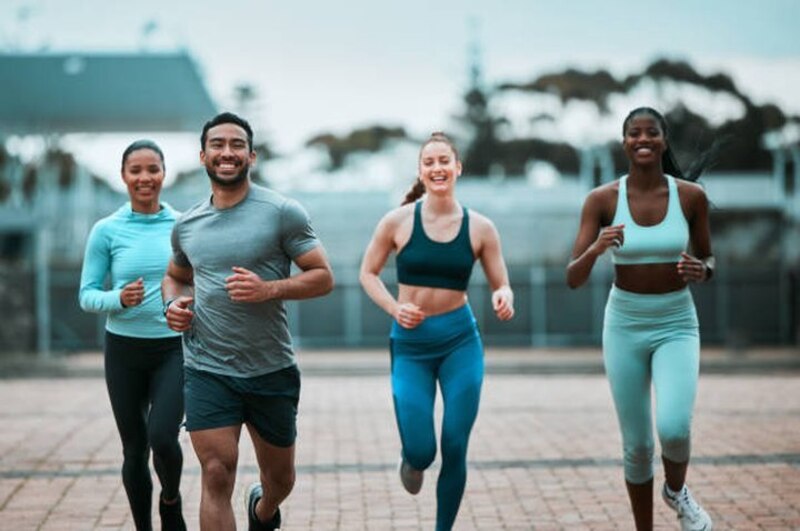 Cuatro amigos corriendo por la ciudad