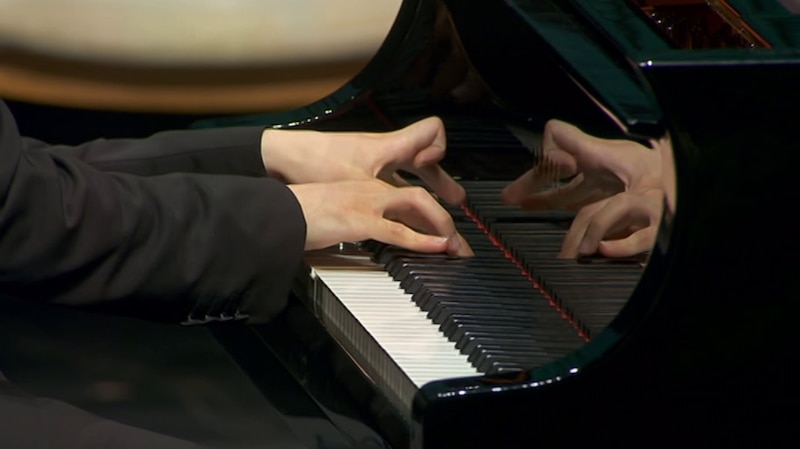 Manos tocando las teclas de un piano