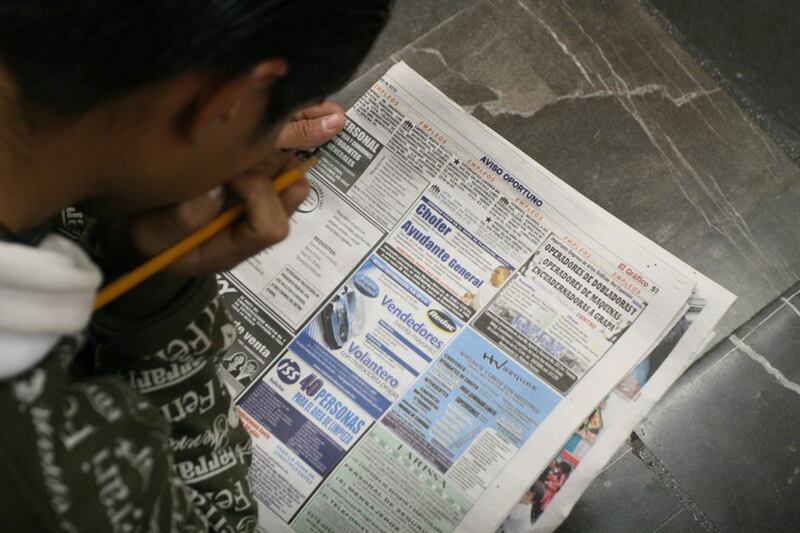 Un hombre lee el periódico en busca de empleo