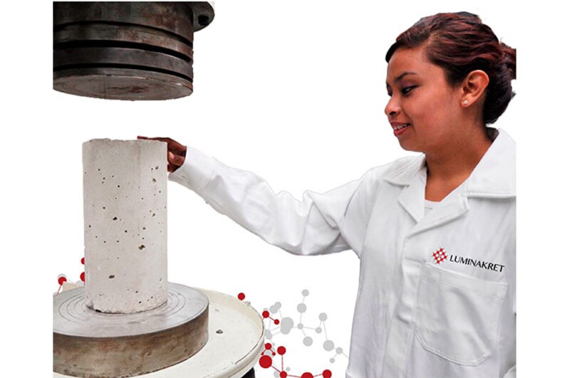 Mujer realizando un ensayo de compresión en un cilindro de concreto