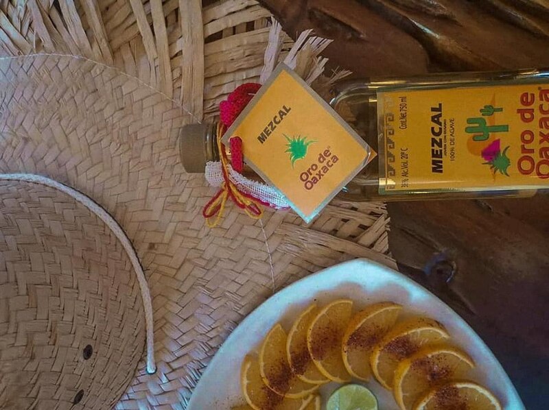 Botella de mezcal con rodajas de naranja y limón