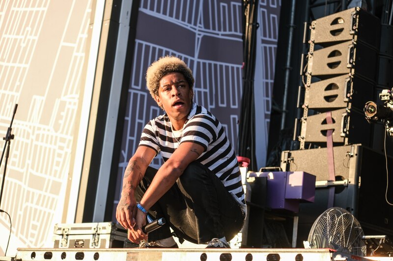Rapero Lil Nas X se agacha en el escenario durante un concierto.