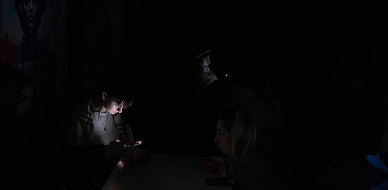 Mujeres mirando sus teléfonos en la oscuridad
