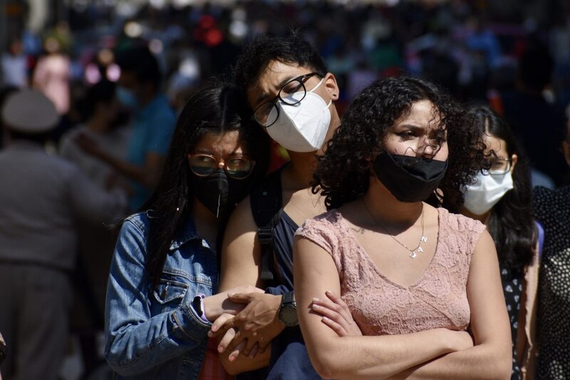 Jóvenes con mascarillas en la calle