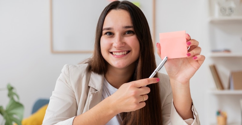 Mujer sosteniendo una nota adhesiva