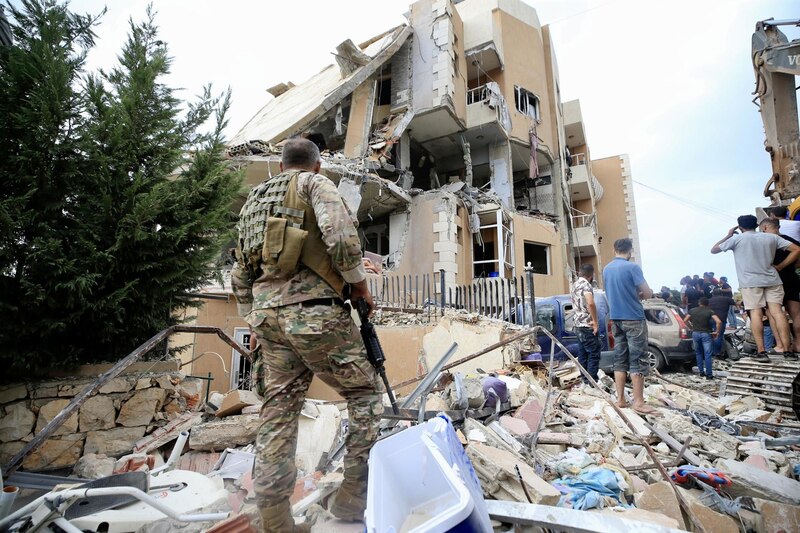 Soldado israelí custodia los restos de un edificio destruido en Gaza