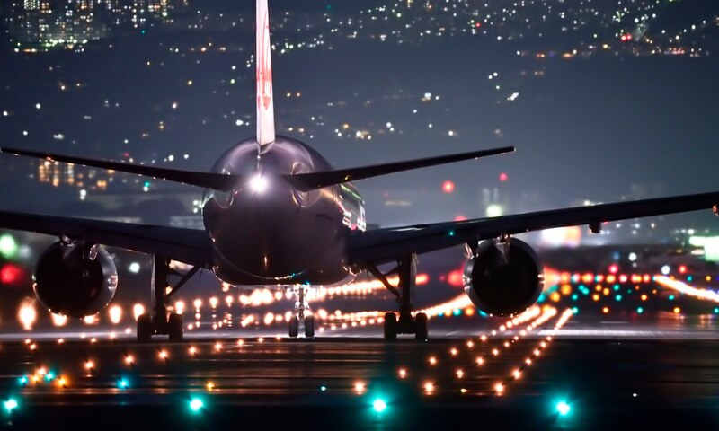 Un avión despega de una pista de aterrizaje en la noche.