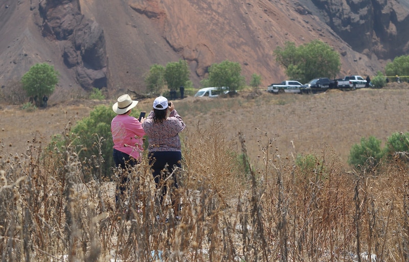 Dos mujeres observan un derrumbe en una mina a cielo abierto