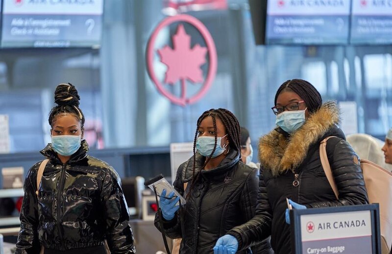Pasajeros con mascarillas en el aeropuerto