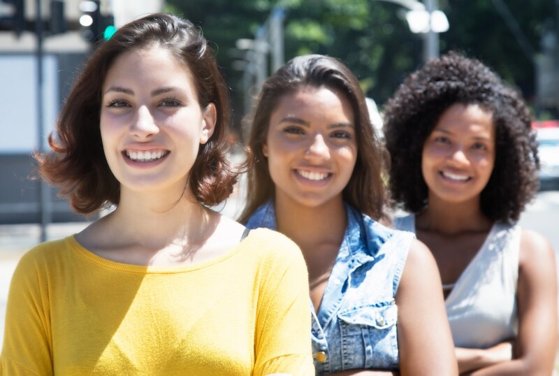 Tres mujeres sonríen a la cámara