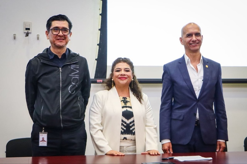 Tres personas sonríen mientras posan para una foto.