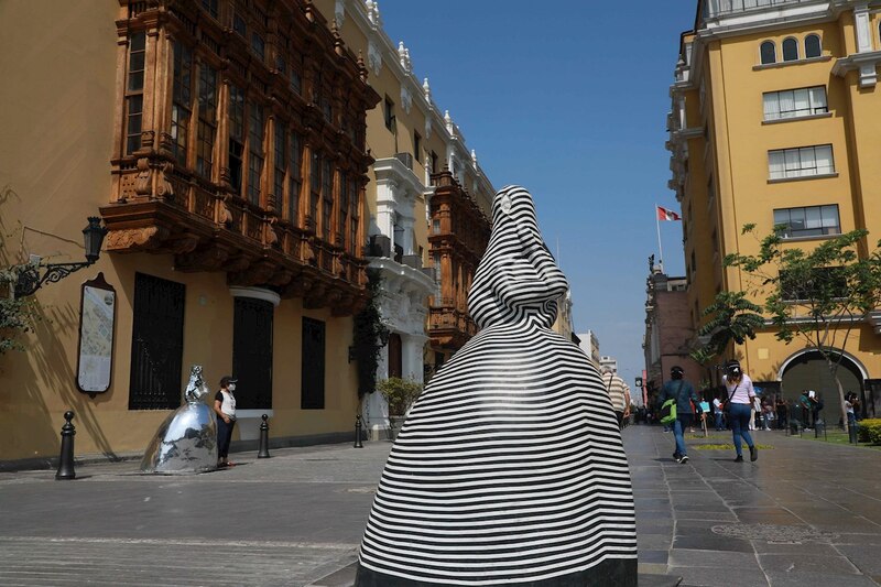 Escultura de mujer con vestido de rayas en blanco y negro