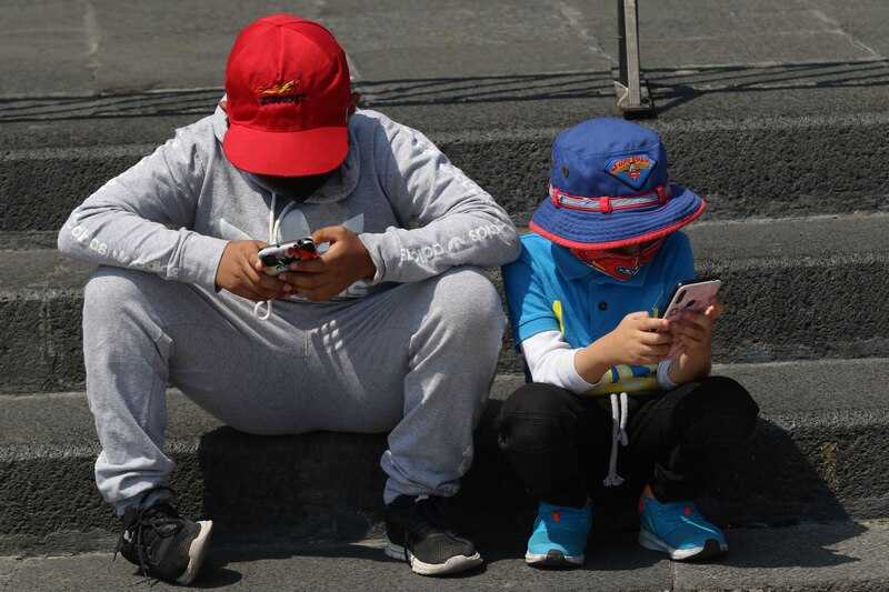 Niños usando teléfonos móviles