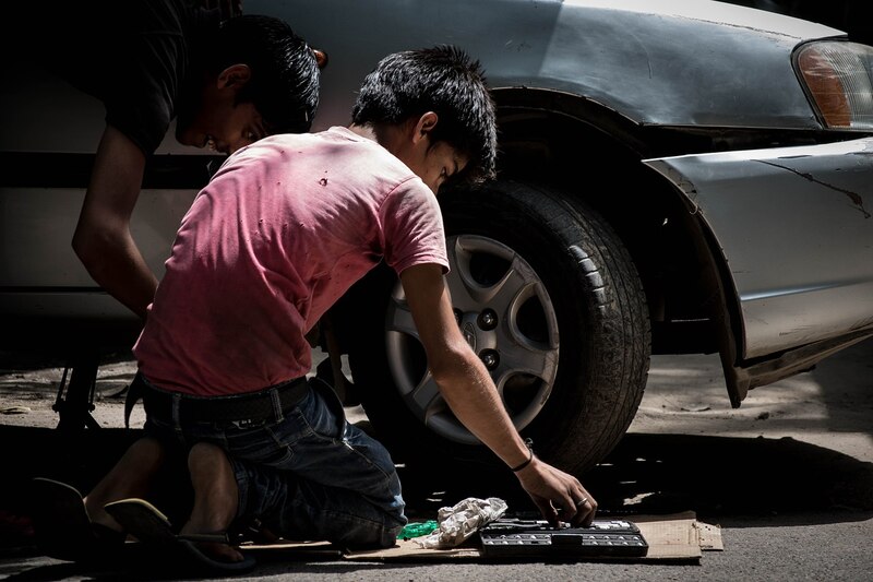 Dos niños arreglando un coche